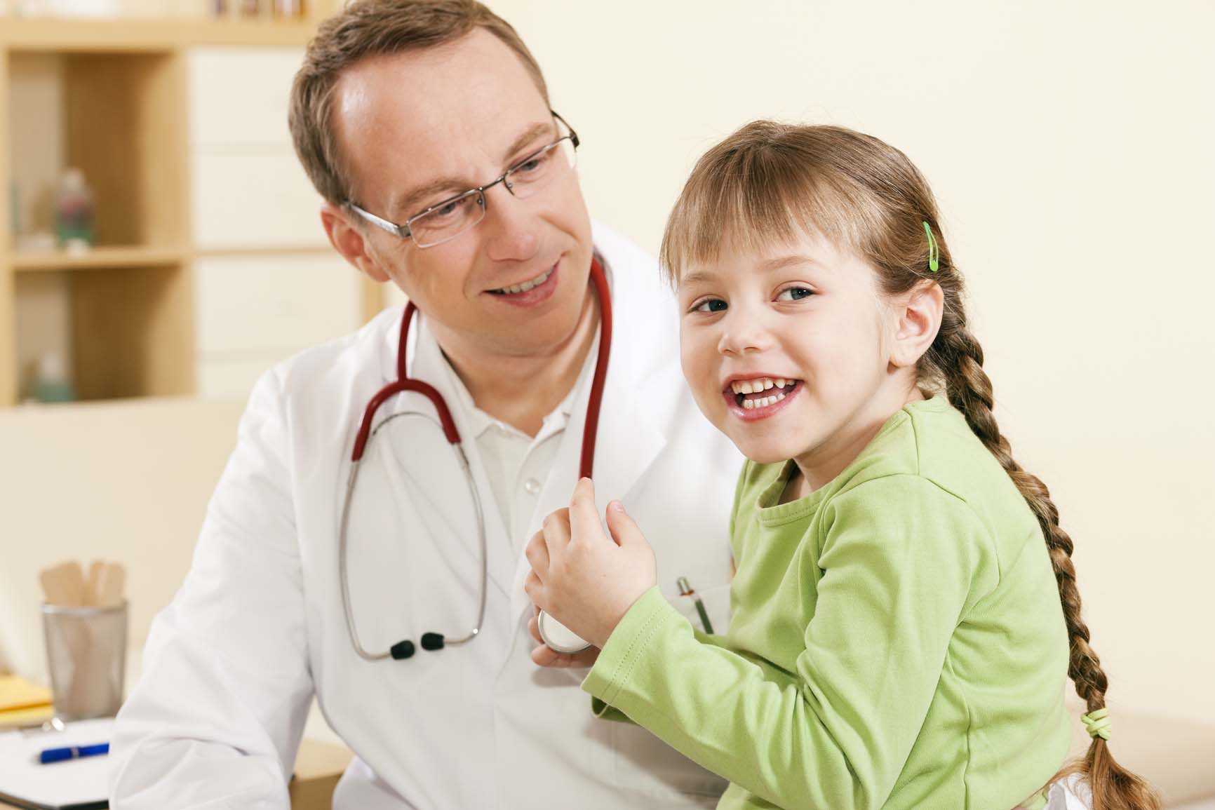 Child patient in his practice, she is examining his stethoscope, friendly and light atmosphere
